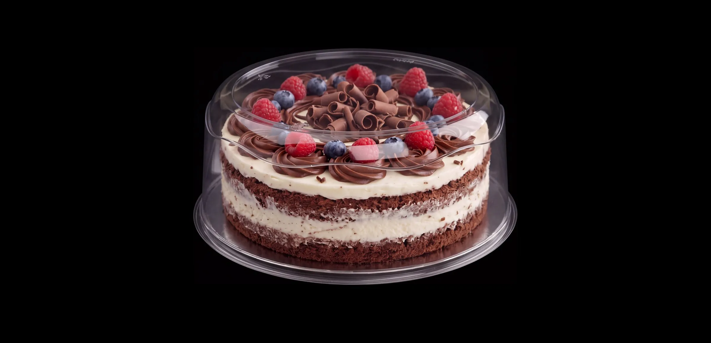 Clear dome cake container on black holding a layered chocolate cake topped with berries