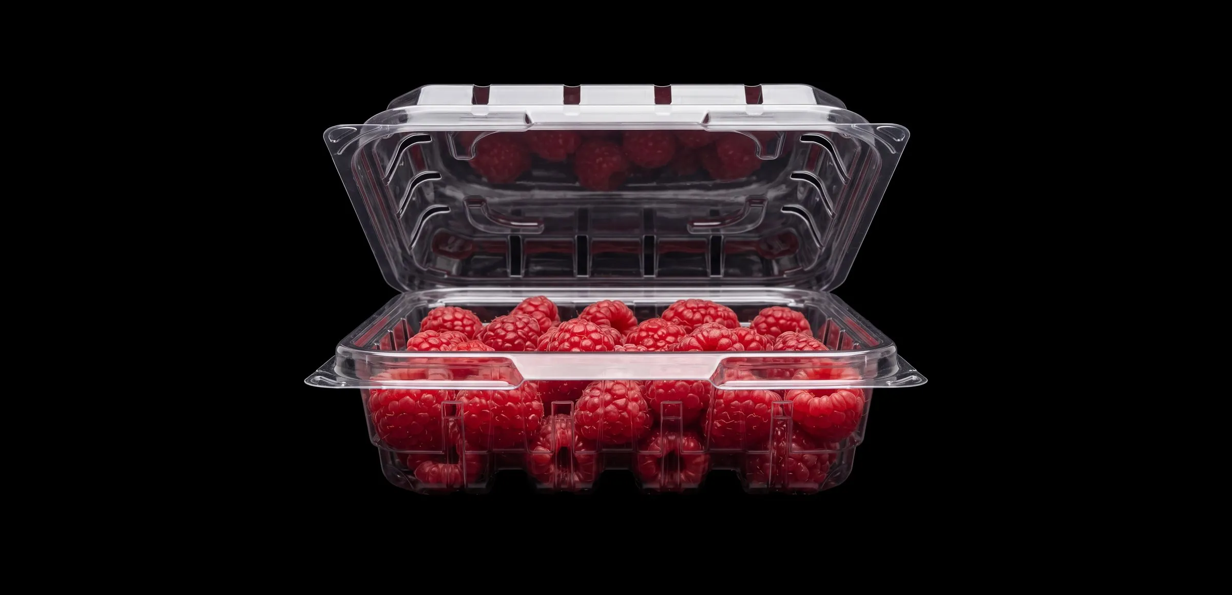 Clear clamshell on black, lid open, filled with fresh raspberries